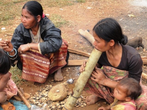 Les enfants mangent une sorte d'amande pendant que la mère fume sa pipe en bambou